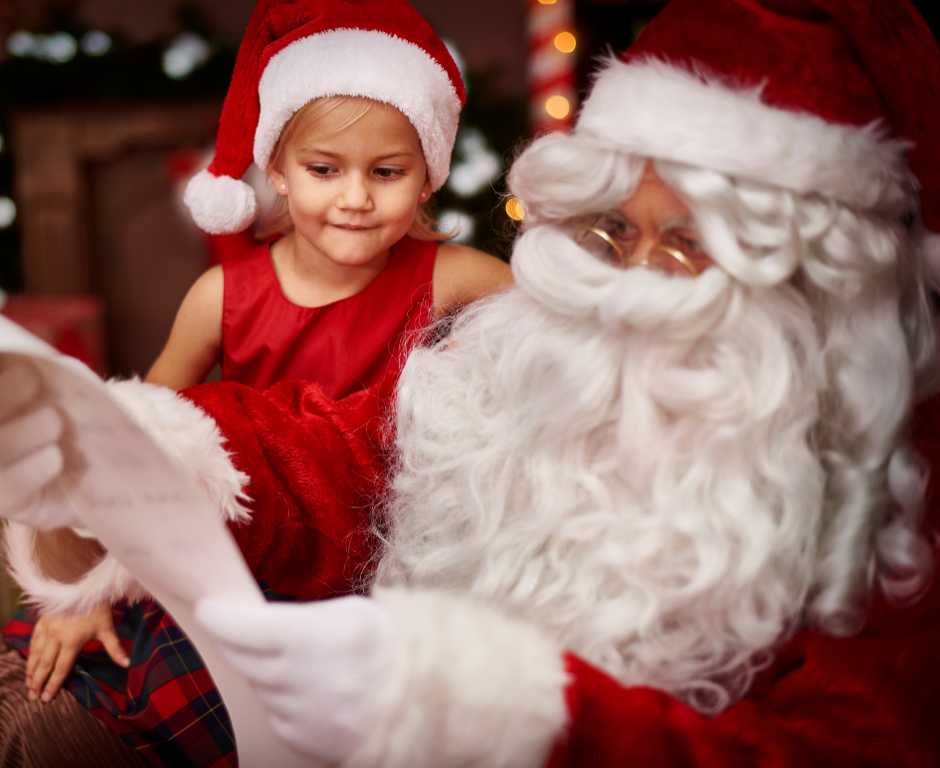 Child enjoying festive moment with Santa in cosy hotel lounge, surrounded by holiday decor and warm ambience.