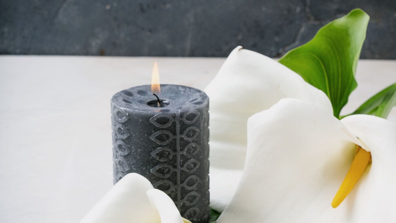 Relaxing space with elegant lilies and a soft candle, offering serene ambiance at our luxury hotel's spa retreat.